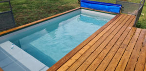 Réalisation d'une piscine container standard 6 mètres hors-sol par TinyPool avec une terrasse surélevée sur Nyon